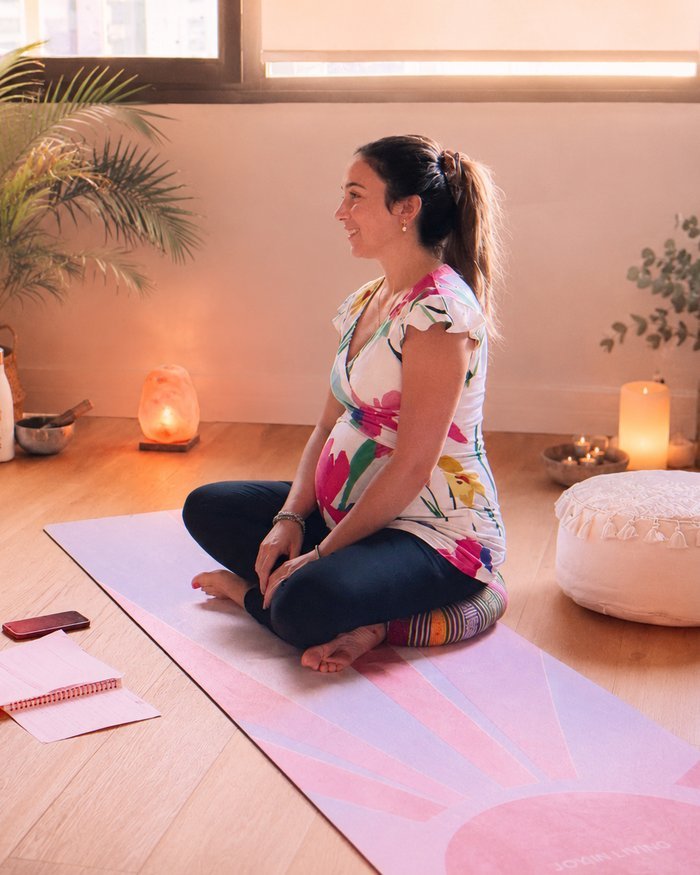 La praticienne de Colibri Spirit assise en tailleur sur son tapis de yoga